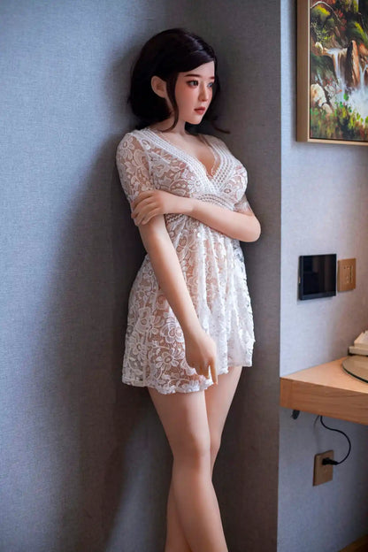 Aliza short dark bob, white lace dress, serene pose, indoor lighting, standing against the wall – perfect wife Asian companion sex doll by TopLoveDoll