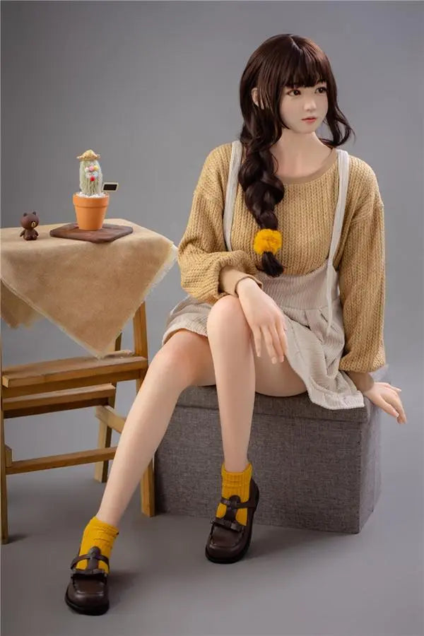 Astrid Asian bangs college sweetheart sex doll, sitting on the storage box chair, looking to a side- first love high school girl next door by TopLoveDoll