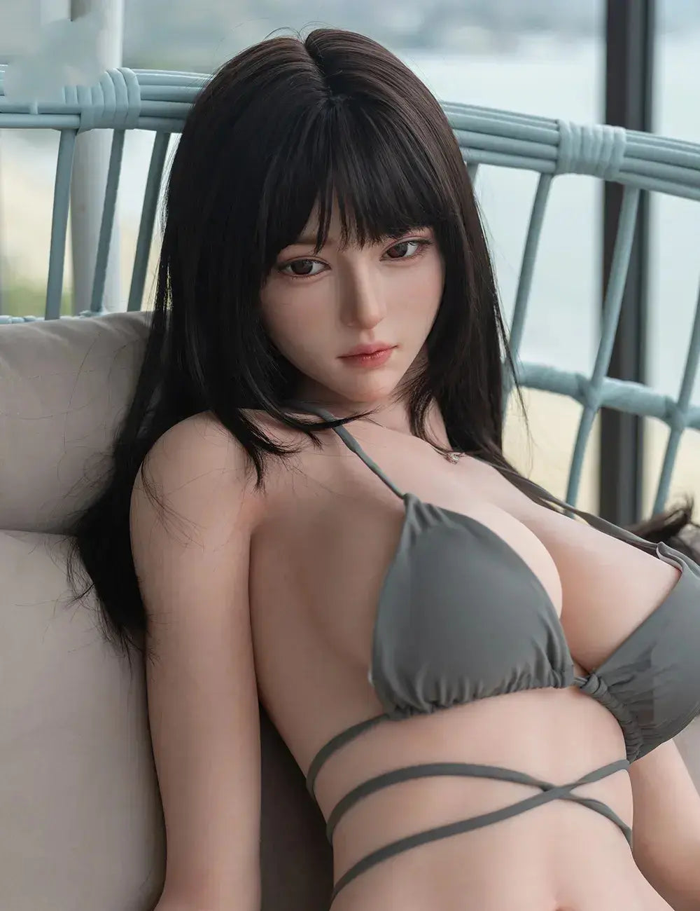 Rookie big boob love doll in grey bikini seated, black bangs, dark eyes, curvy figure, lifesize customizable sex robot by TopLoveDoll