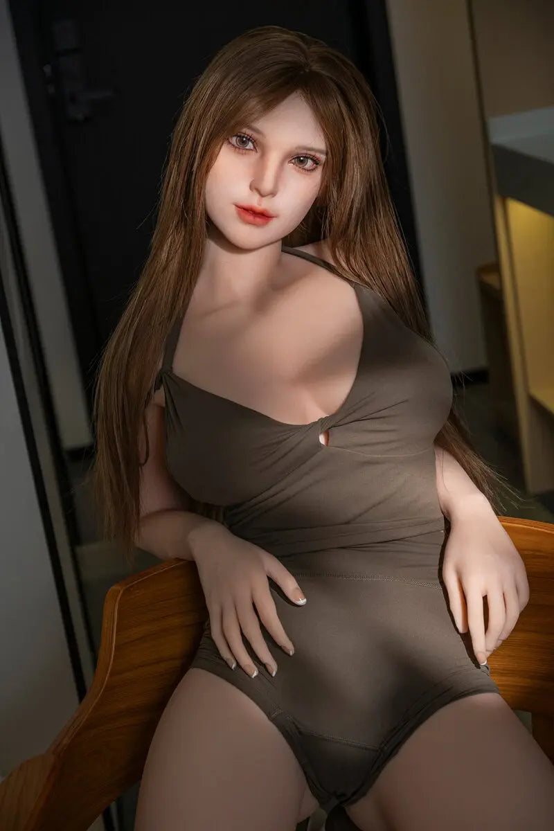 Gadora beautiful brunette doll seated in a wooden chair, with long brown hair and an olive outfit