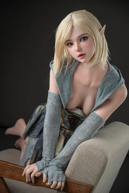 Portrait of Elowen blonde elf sex doll leaning over a wooden armrest, showing pointed ears, green eyes and a gray-green fantasy outfit.