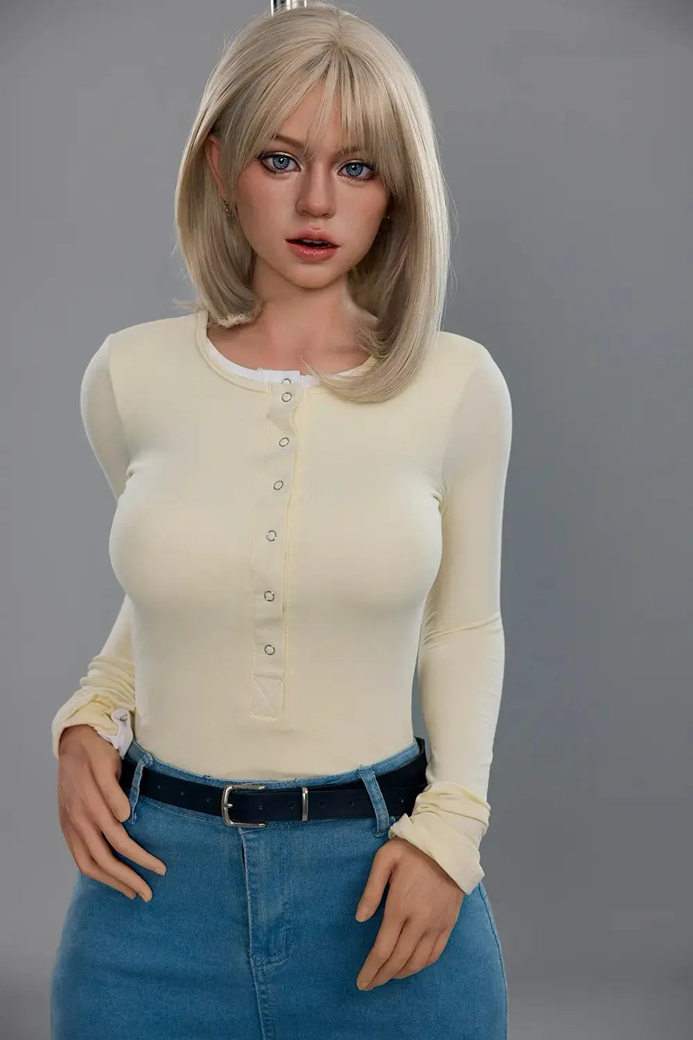 Front portrait of Marisol blonde GND doll with her hands near her hips, showing blue eyes, blonde bangs and a cream top.