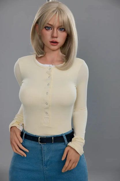 Front portrait of Marisol blonde GND doll with her hands near her hips, showing blue eyes, blonde bangs and a cream top.