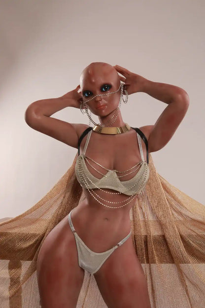 Closer front view of Vaelis sex doll with a silver two-piece outfit, face chains and a gold-toned collar