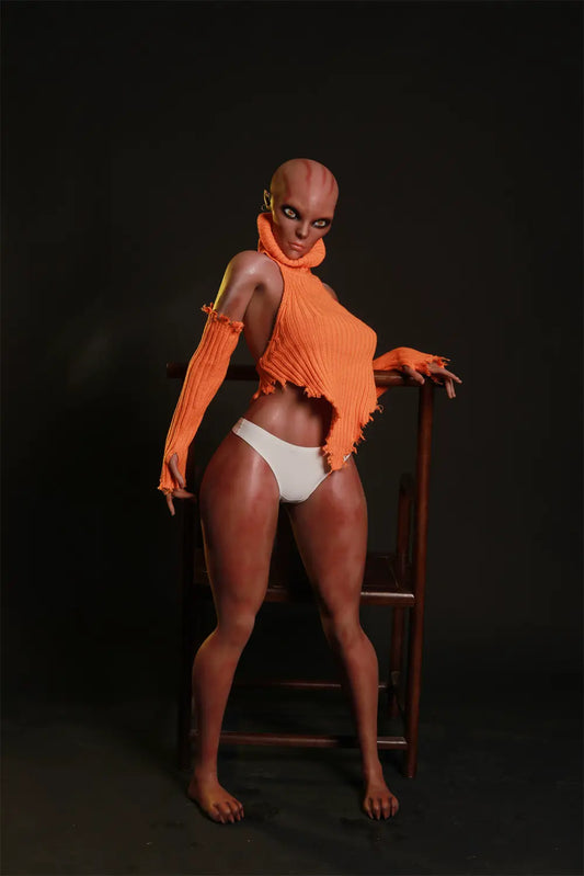 Nyxie alien sex doll standing beside a wooden chair in an orange knit top, matching sleeves and white briefs