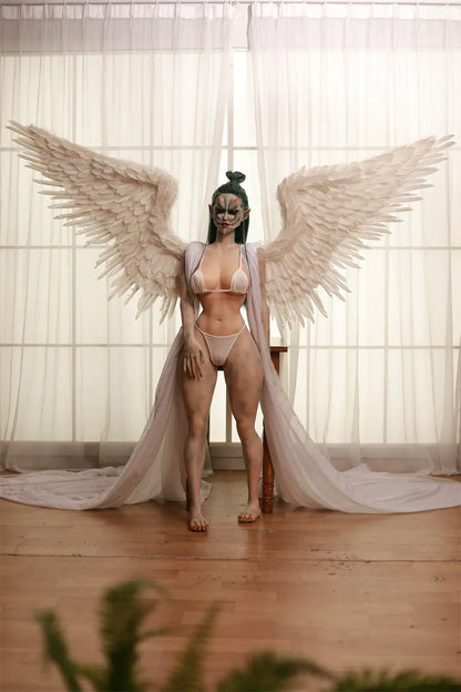 Full-length front view of Morveth dark wraith sex doll with white feathered wing accessories beside a bright window