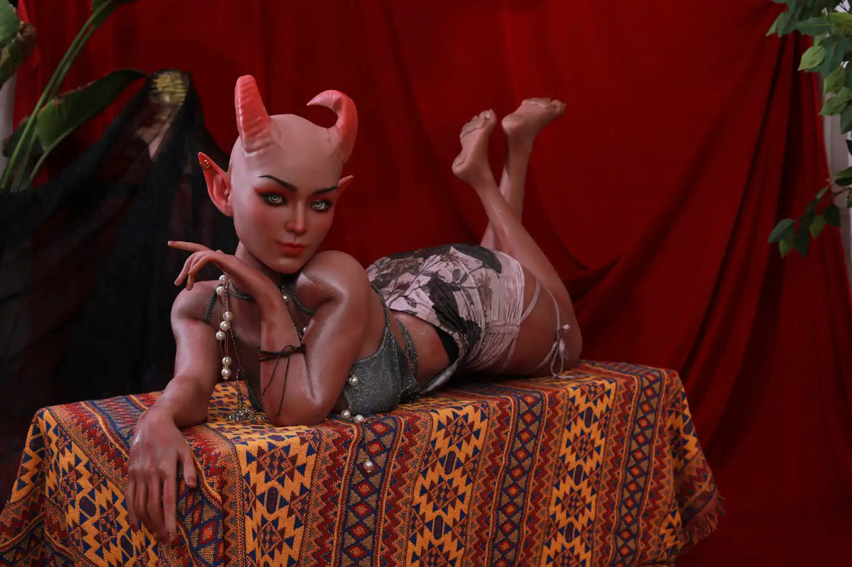 Wide view of Tauris sex doll reclining on a patterned platform against a red backdrop