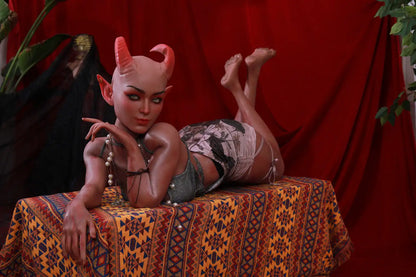 Wide view of Tauris sex doll reclining on a patterned platform against a red backdrop