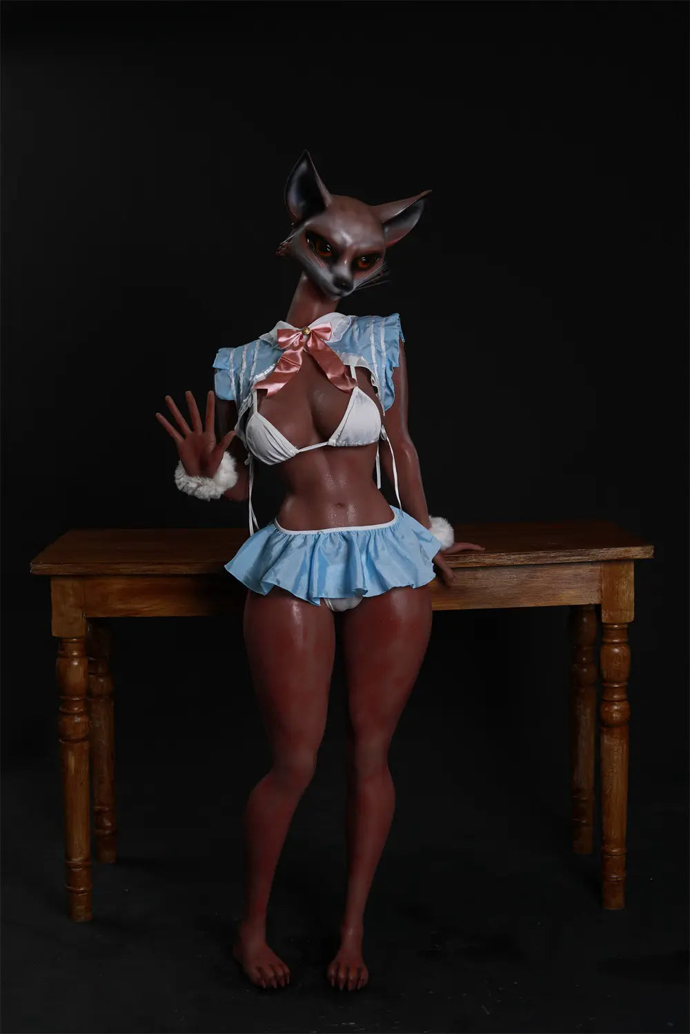 Vesper anthropomorphic fox sex doll standing beside a wooden table in a blue-and-white costume with a pink bow