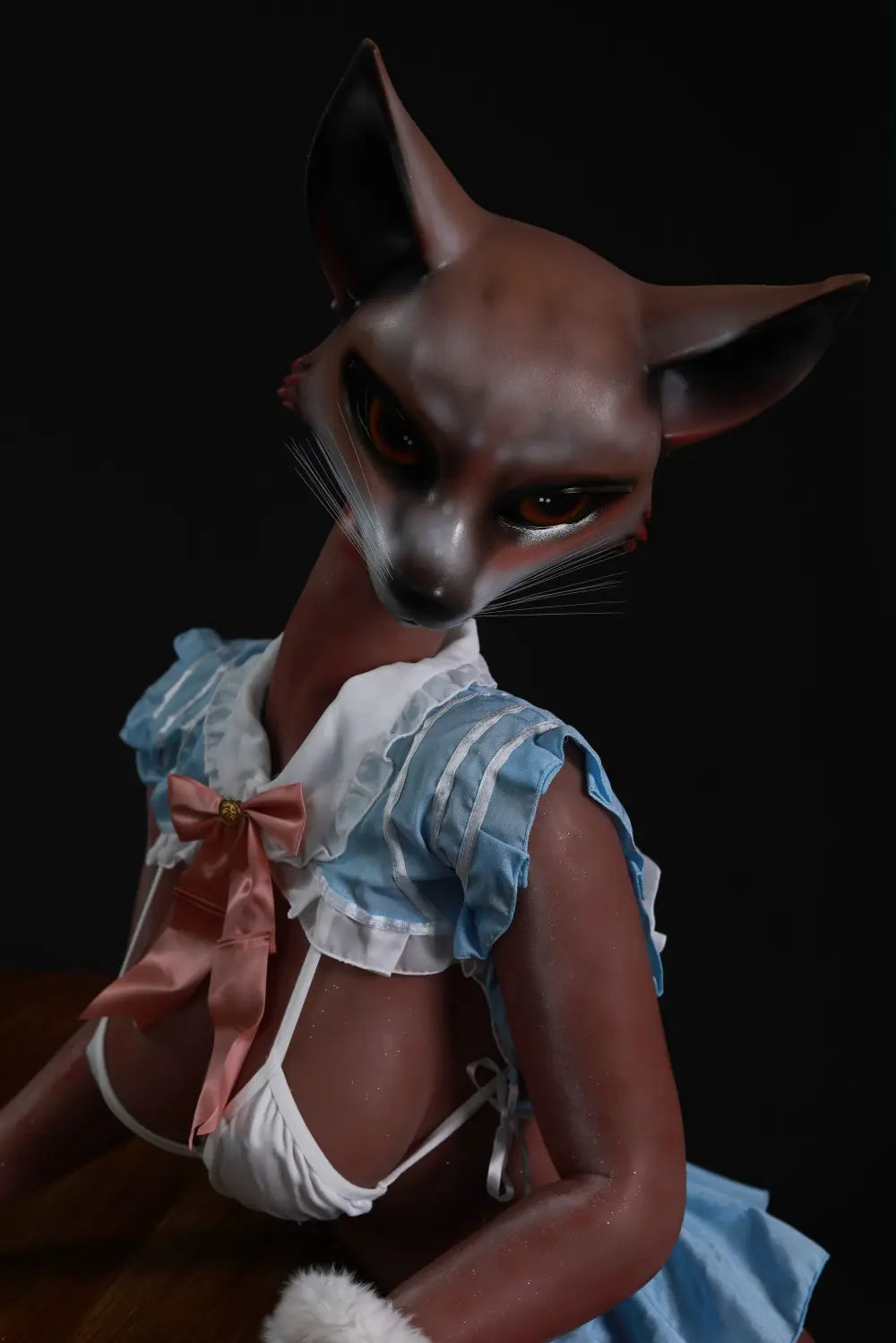 Close-up of Vesper fox-shaped head with pointed ears, whiskers and a pink costume bow
