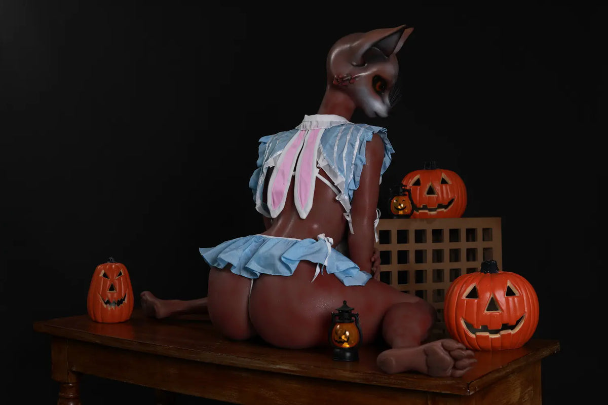Wide rear view of Vesper fox sex doll seated on a wooden table among Halloween pumpkin decorations