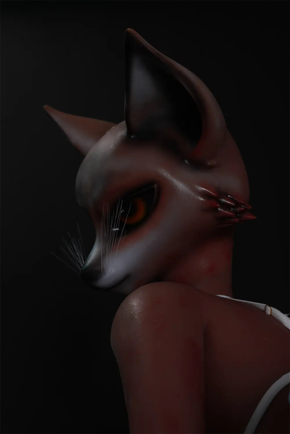 Side close-up of Vesper fox head turned over one shoulder against a dark background