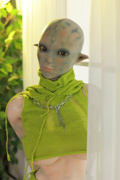 Sylvara sex doll without the hood, showing a hairless fantasy head and green leaf-like collar