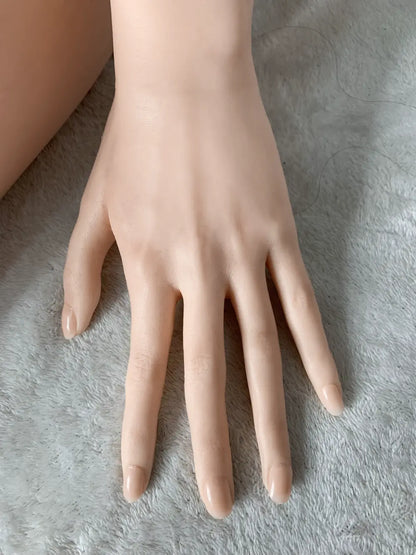 Factory detail photo of Mintori sex doll's hand resting on a white textured surface