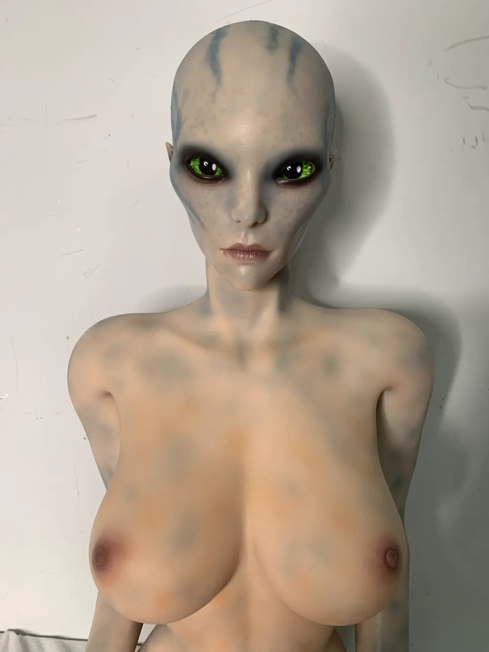 Opposite three-quarter factory reference view of Aelyth sex doll with hands resting on the thighs