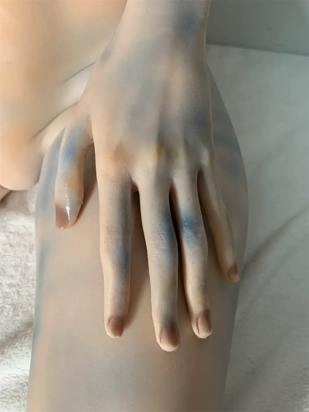 Factory close-up of Aelyth's alien face showing dark eye surrounds and pale blue head markings