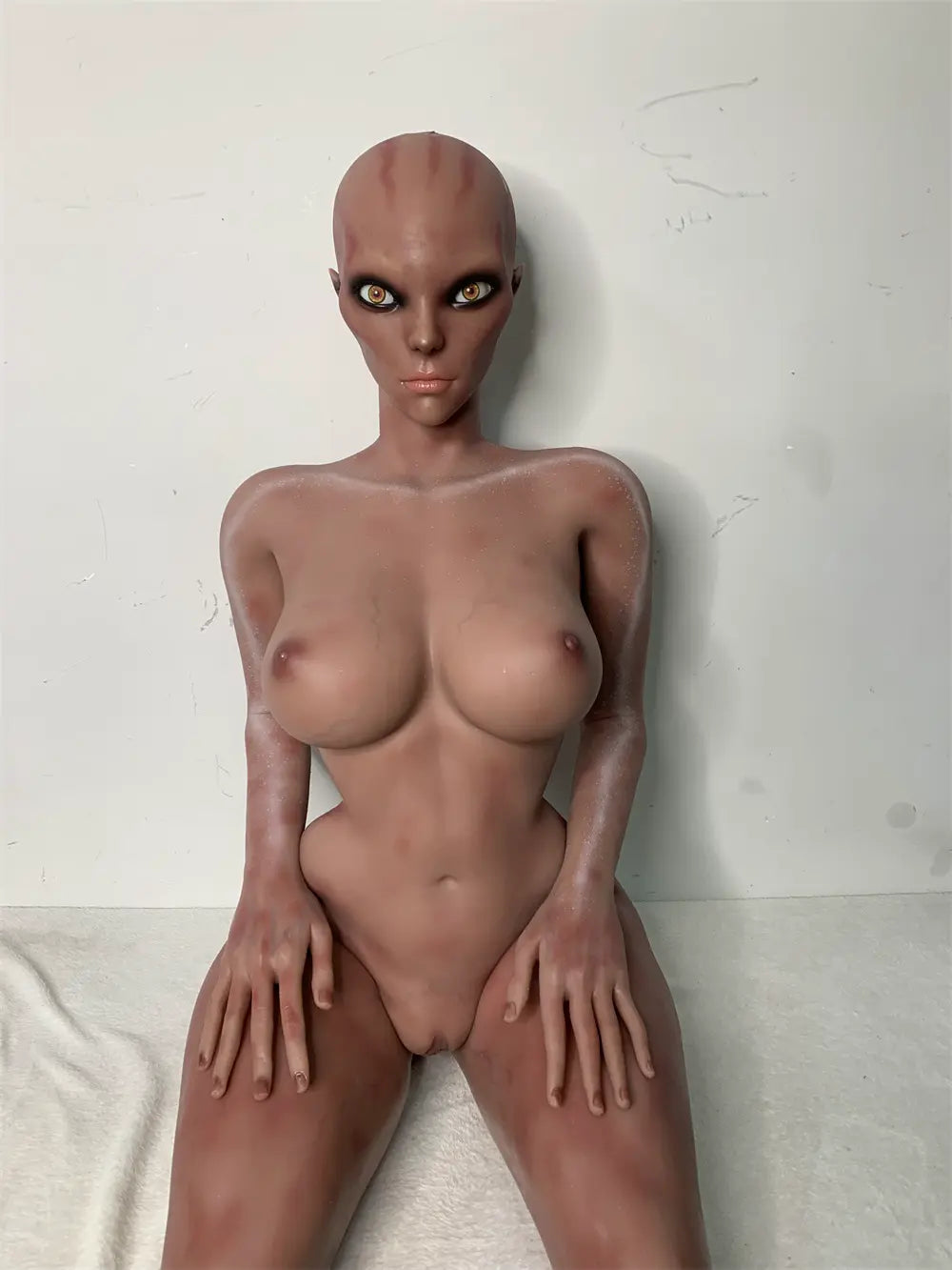 Front factory reference view of Nyxie sex doll showing the alien head, torso and hands on the thighs