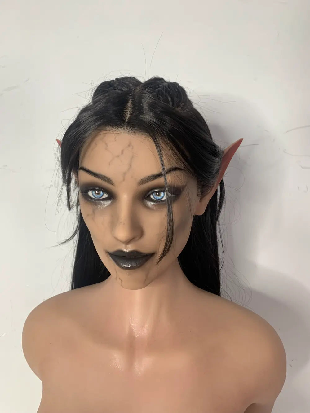 Factory close-up of Vhaera sex doll's face with pointed ears and swept-back dark hair