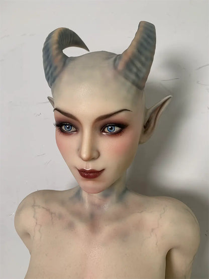 Factory close-up of Veltris sex doll's fantasy face showing the curved horns and dark eye surrounds