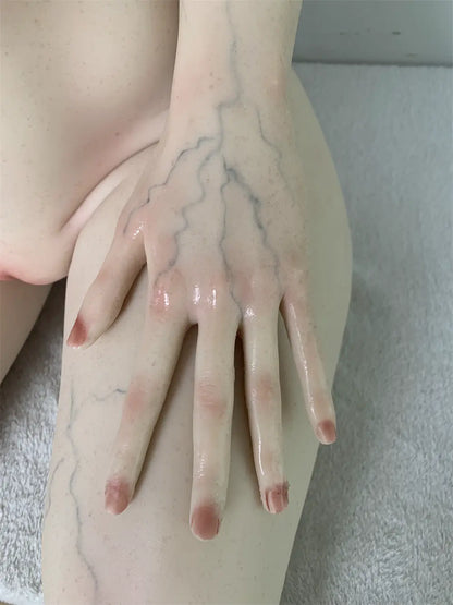 Factory detail photo of Veltris sex doll's hand resting on the thigh, showing sculpted fingers and nails