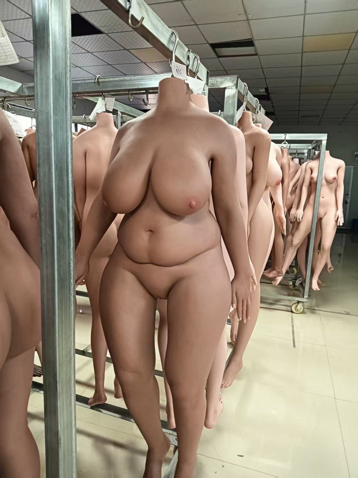 162cm J-cup BBW full-silicone sex doll body in tan skin, headless front view in the factory